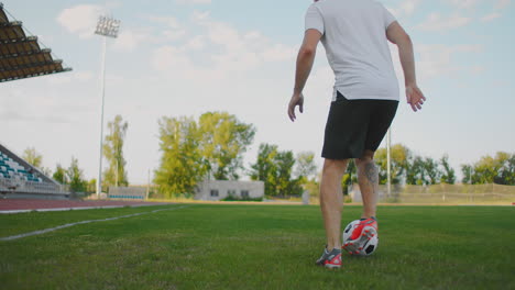 Nahaufnahme-Eines-Männlichen-Fußballspielers,-Der-Mit-Einem-Fußball-Auf-Dem-Fußballfeld-Im-Stadion-Läuft-Und-Dabei-Hervorragende-Dribblings-Und-Ballkontrolle-Demonstriert.